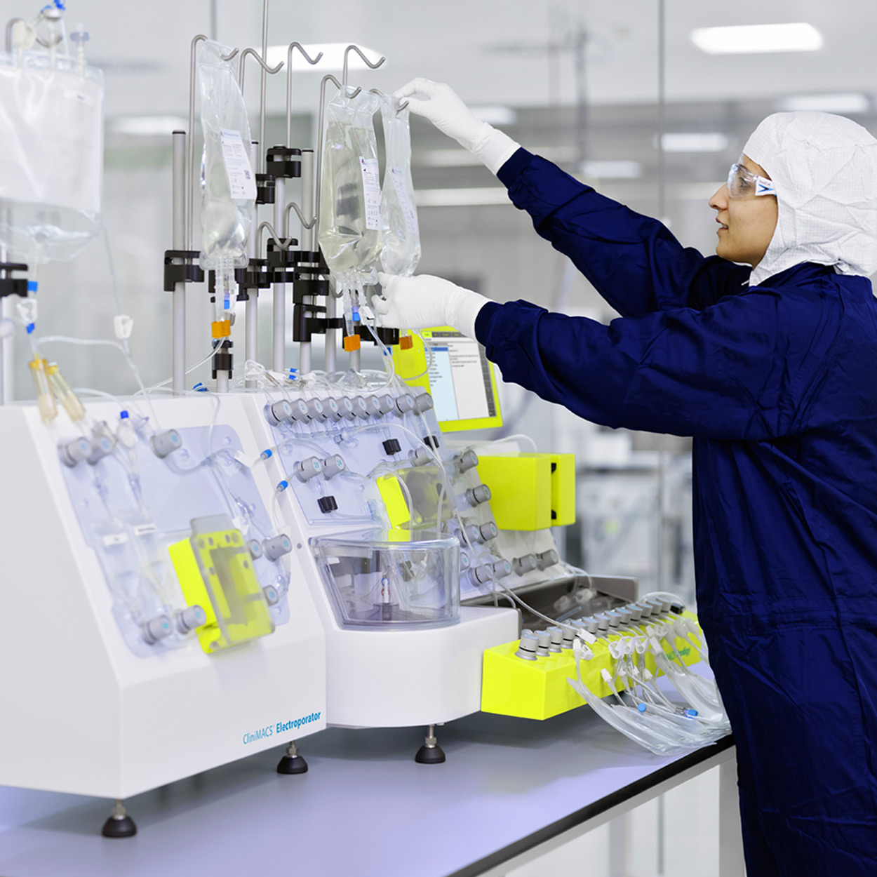 Female in clean room attire working on a CliniMACS Prodigy.